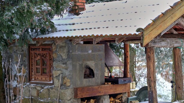 A rustic stone building with a wooden door, a chimney, and a small outdoor seating area. - Feng Shui Cottage in Marlhes' Nature (Marlhes)