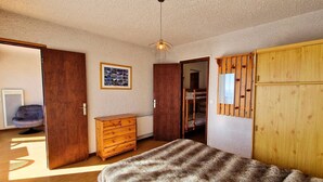 A bedroom with a bed, wooden dresser, and wardrobe. - Apt 6 pers, south balcony, central, pets allowed, parking, WiFi, dishwasher (Saint-Michel-de-Chaillol)