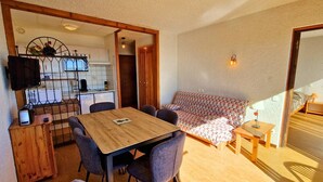 A compact living space with a dining area, kitchenette, and a sofa. - Apt 6 pers, south balcony, central, pets allowed, parking, WiFi, dishwasher (Saint-Michel-de-Chaillol)