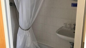 A bathroom with a shower curtain, a sink, and a mirror. - City Hotel Kaiserhof (Saarbrücken)