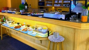 Ein reichhaltiges Buffet mit verschiedenen Speisen und einer Kaffeestation.
