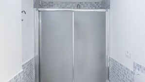 A bathroom with a shower stall, tiled walls, and a white door. - N198 - Numana, new three-room apartment with garden and swimming pool (Sirolo)