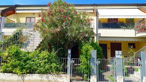Un bâtiment à deux étages doté d’un balcon, d’un escalier et d’un espace jardin.