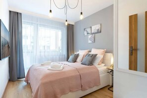 Relax in a serene space with a large bed, bedside table, and elegant artwork.