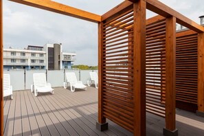 Relax in style on this outdoor deck with comfortable lounge chairs and a charming pergola.