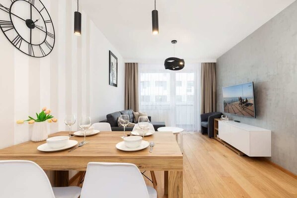 Relax in this stylish living room with a flat-screen TV and dining area.