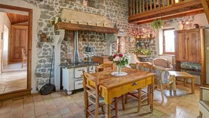 Una cucina rustica con pareti in pietra, mobili in legno e un lampadario.