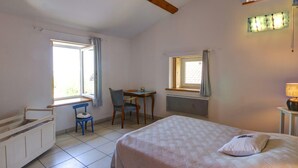 A bedroom with a bed, a desk, a chair, and a window. - Gîte Bellevue in Marols for 6 people with charming enclosed yard (Marols)