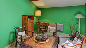 A dining area with a table, chairs, and a lamp. - Gîte Bellevue in Marols for 6 people with charming enclosed yard (Marols)