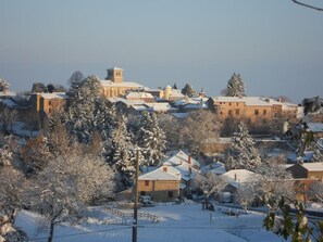 Een besneeuwd dorp met traditionele gebouwen en een opvallende toren.