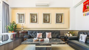 A modern living room with a sofa, coffee table, and framed artwork on the wall. - Penghu Water Reflection (Magong)