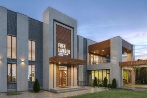 A modern hostel with a prominent sign, large windows, and a well-lit entrance. - Freelander Work and Travel Hostel (Bishkek)