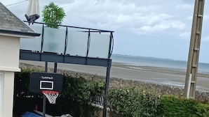 Un campo da basket con un canestro a marchio Tarmac, una palla blu e una gialla, e uno scivolo sullo sfondo.