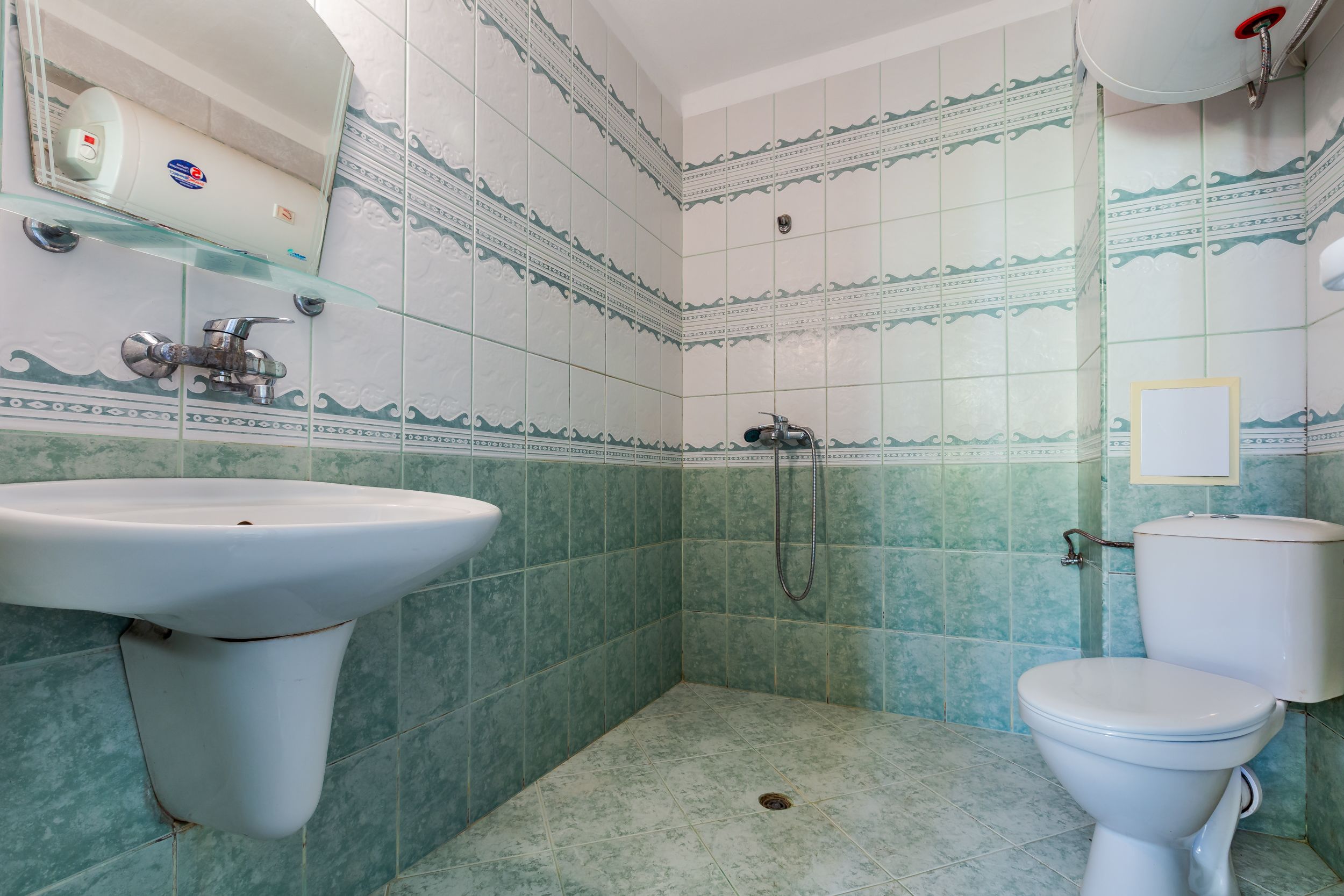 A bathroom with a sink, toilet, and shower.