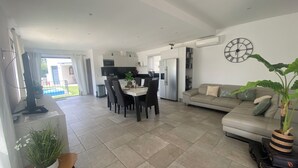 A spacious living area with a dining table, sofa, and a large potted plant. - Provencal detached villa (La Gaude)