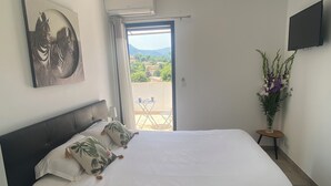 A bedroom with a large bed, a painting of zebras, a TV, and a view of the outdoors. - Provencal detached villa (La Gaude)