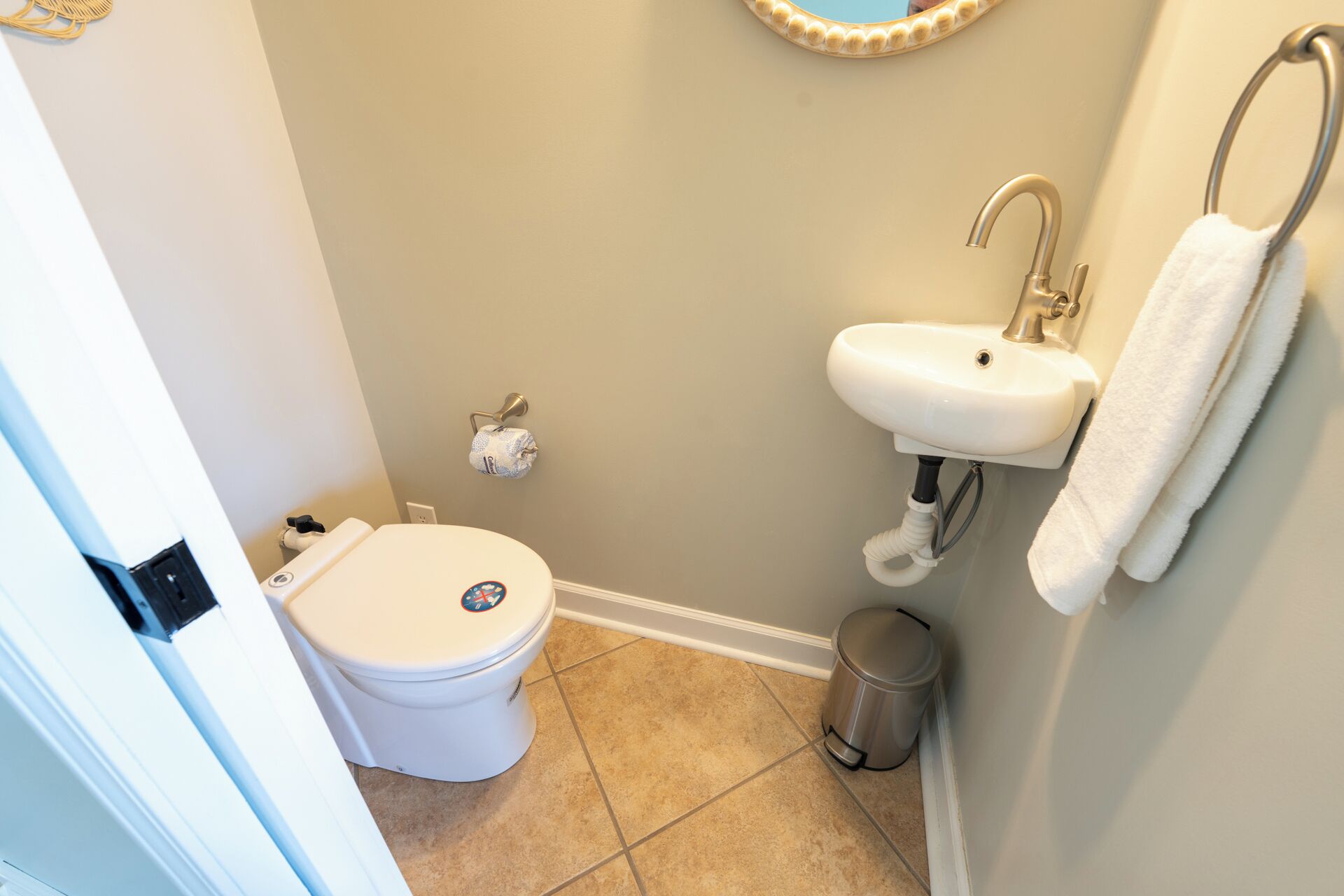 Un baño con inodoro, lavamanos y cubo de basura.