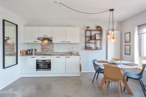 Enjoy cooking in this well-equipped kitchen with an oven, range hood, and dining area.