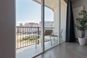Enjoy the city view from this balcony with a potted plant and metal railing.