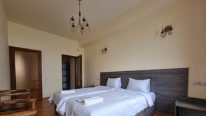 A bedroom with a large bed, wooden furniture, and a chandelier. - Vanatun Monastery Stay (Dilijan)