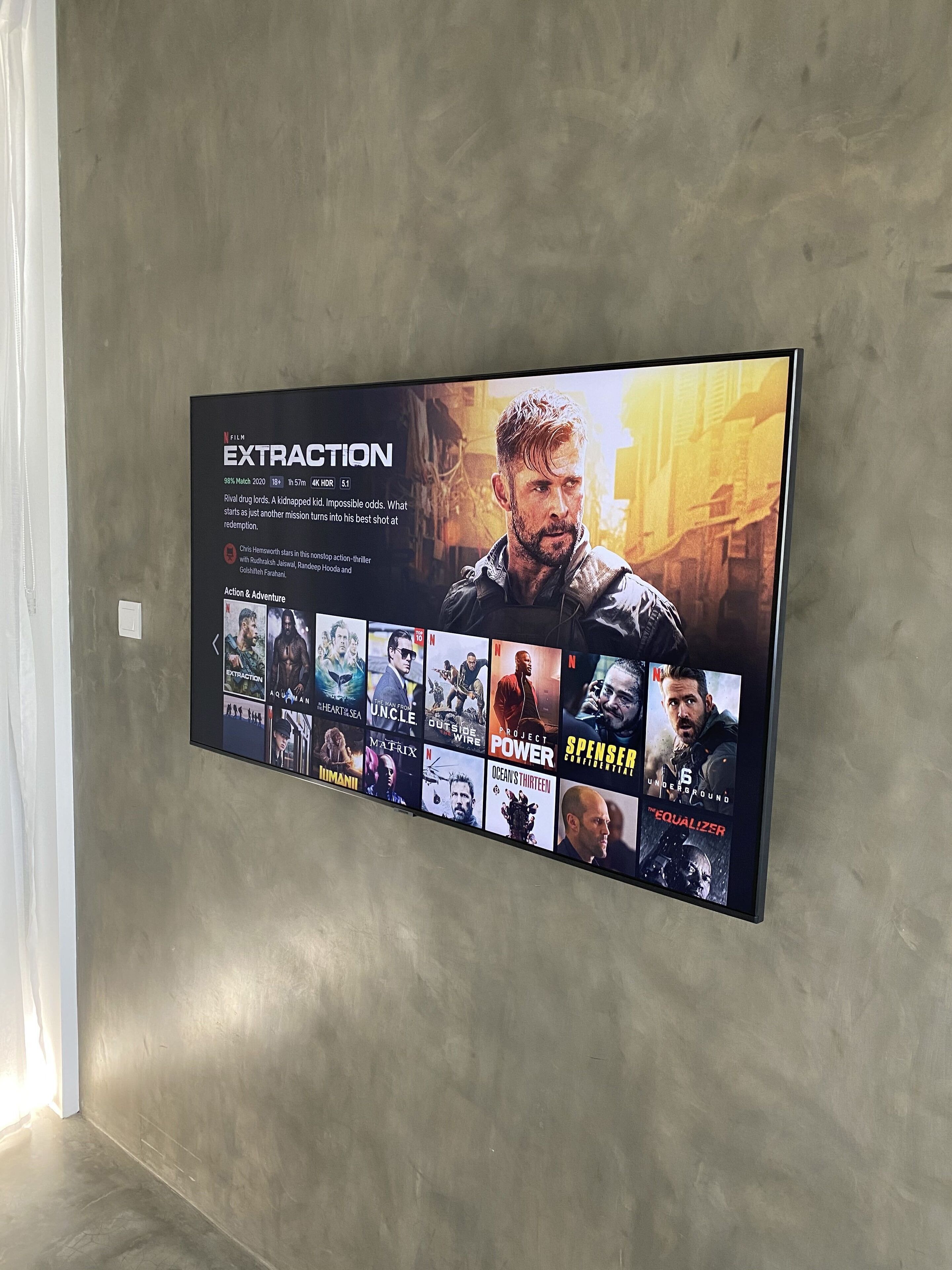 A wall with a poster of the movie 'Extraction' and a selection of other movie posters.