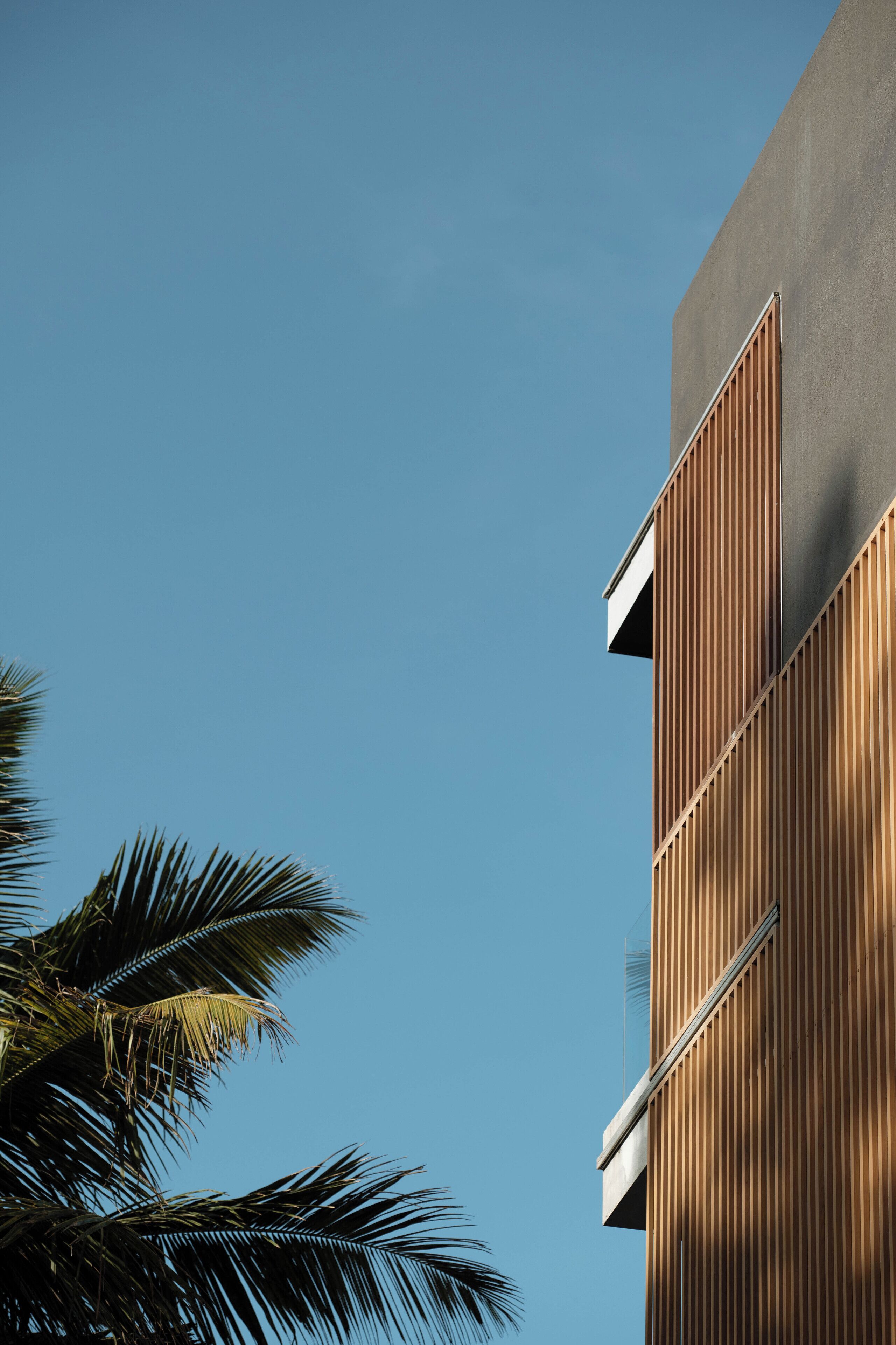 Um edifício moderno com fachada de madeira e uma seção superior preta.