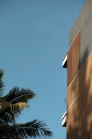 Un edificio moderno con fachada de madera y sección superior negra.