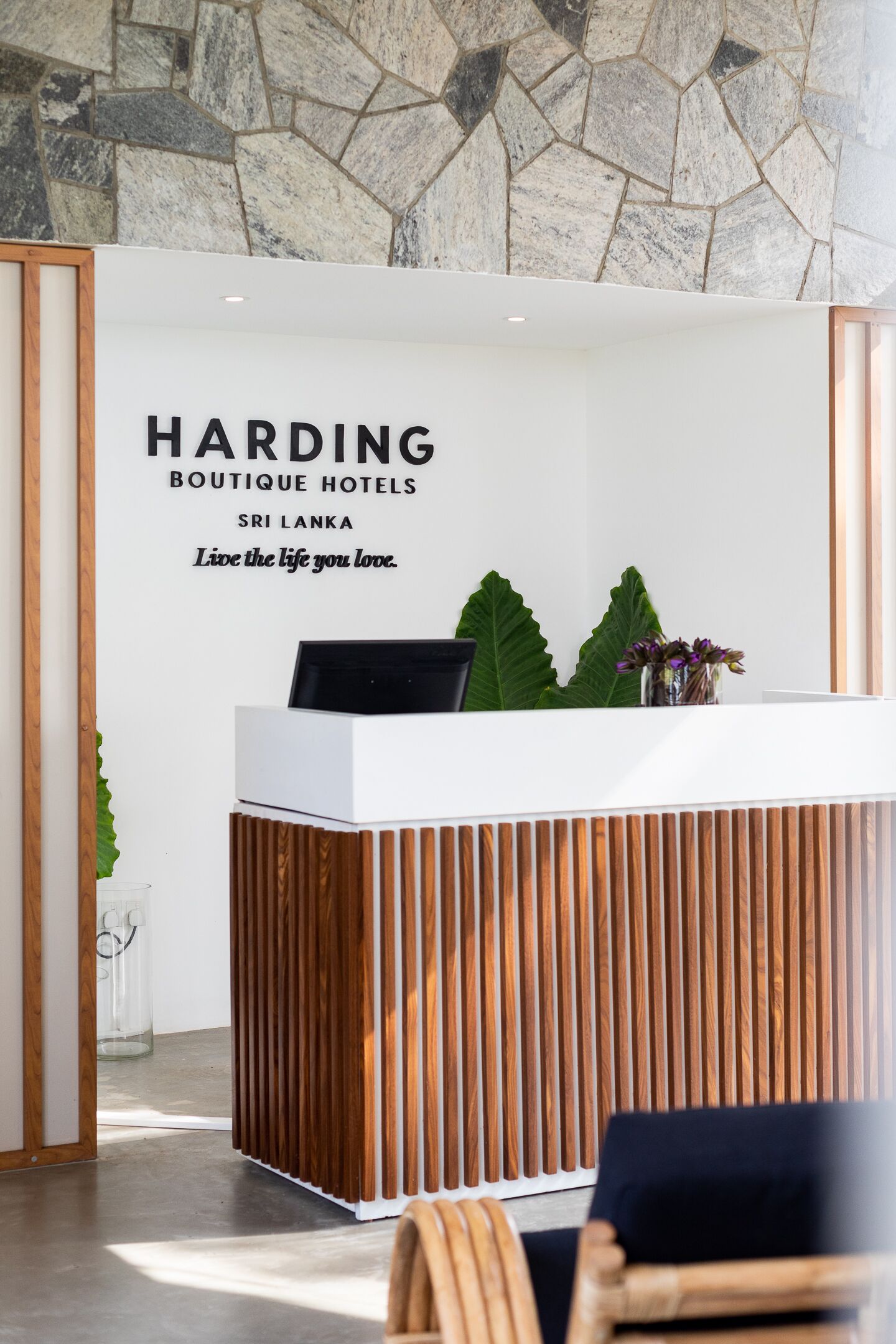 Un mostrador de recepción con un cartel que dice "Harding Boutique Hotels Sri Lanka" y el lema "Vive la vida que amas".