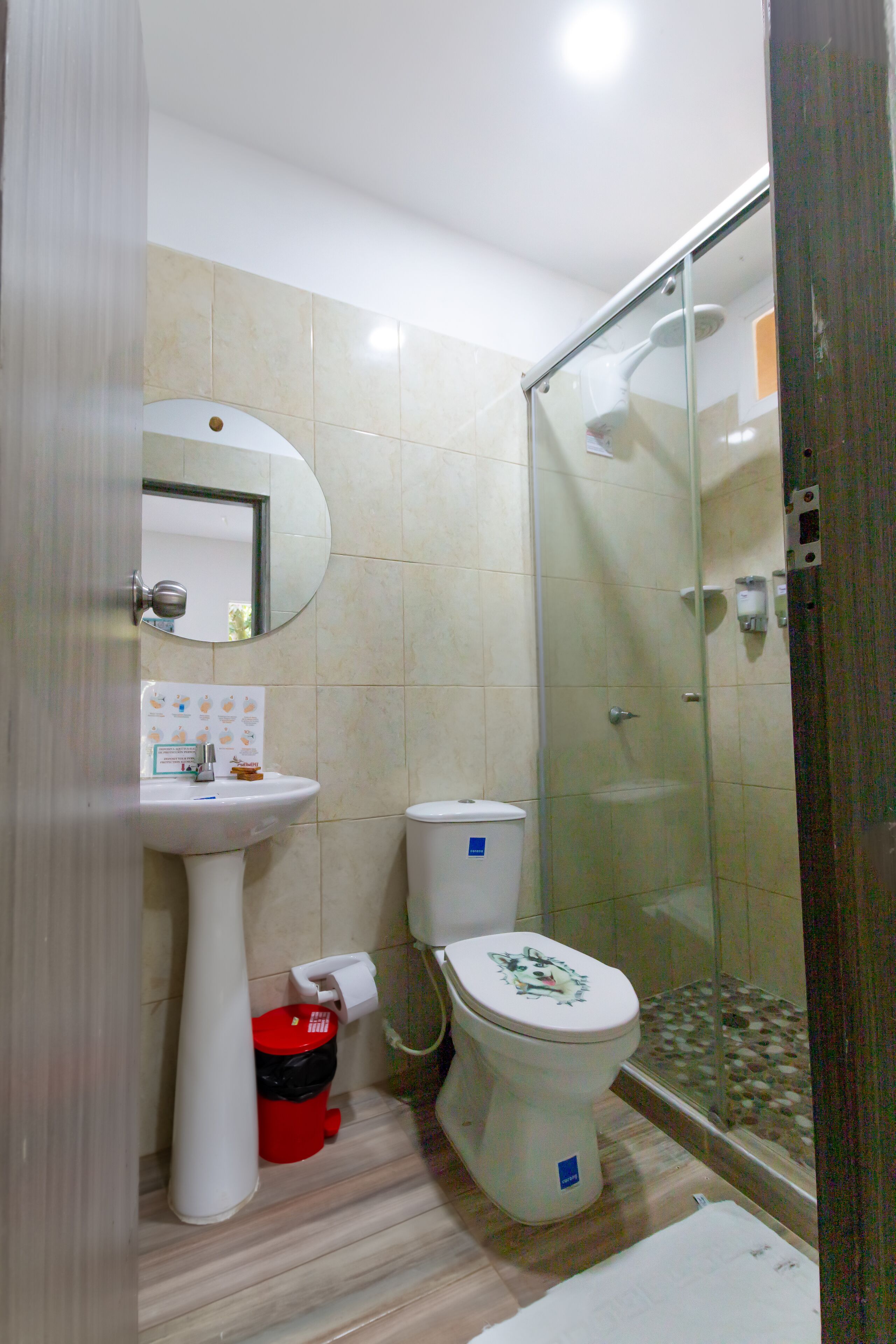 Un bagno con il water, lavandino e cabina doccia in vetro.