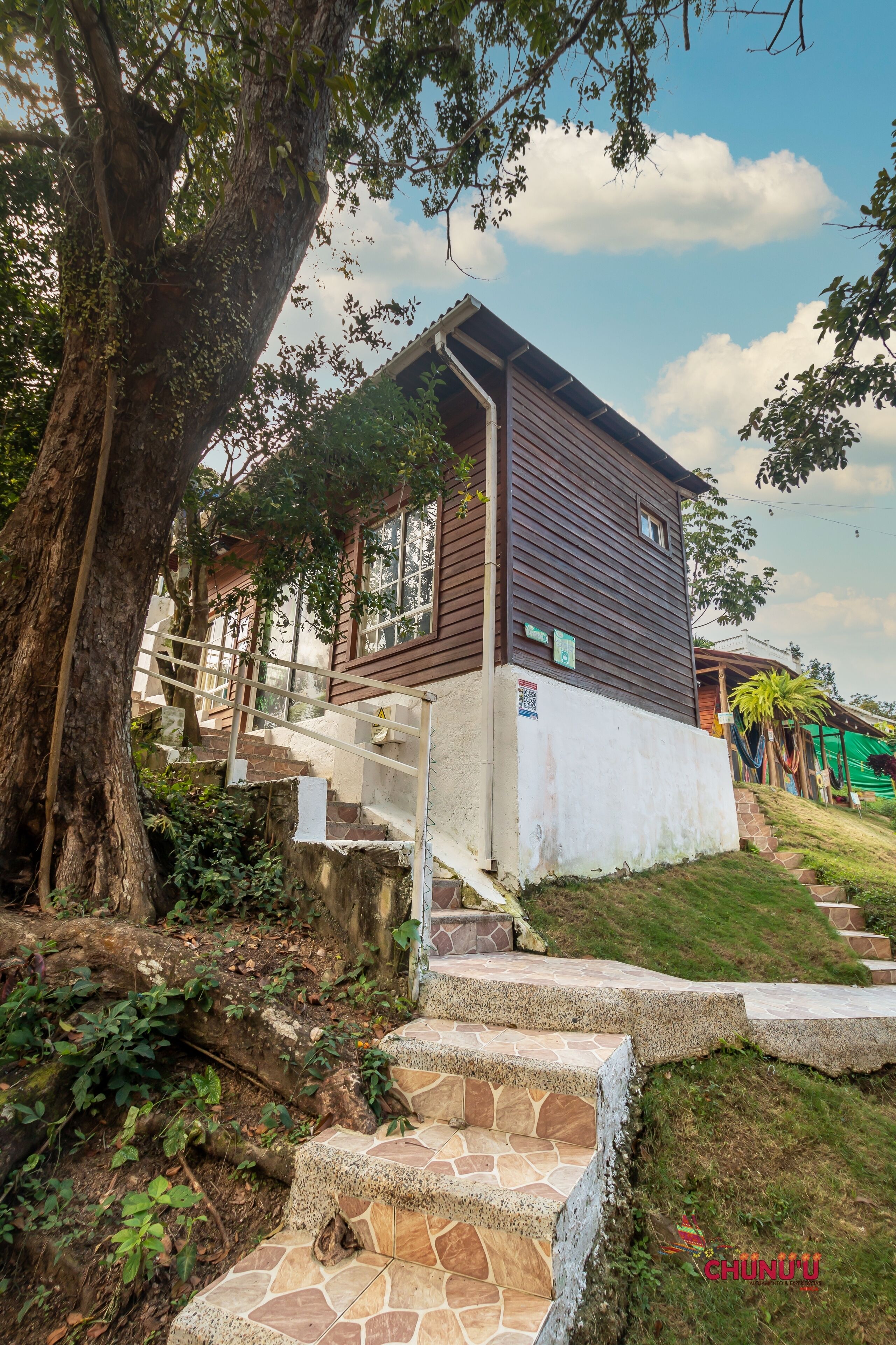 Ein rustikales Holzhaus mit einer Steintreppe, die zu einer Veranda führt.
