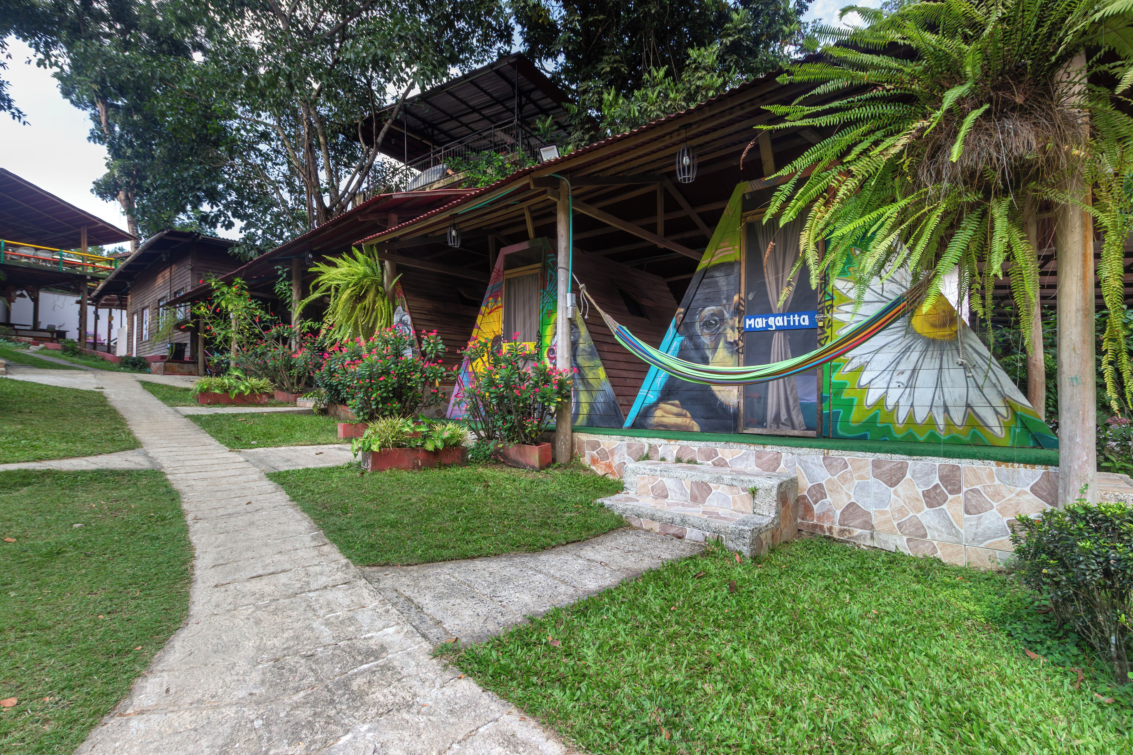 A building with a stone facade, a hammock, and a mural.