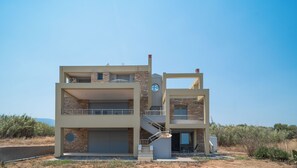 Une maison moderne à deux étages, dotée d’un balcon, d’un escalier et d’un garage.