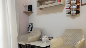 A modern living room with two beige armchairs, a small table, and a decorative item on the table. - Orange Central Studio / Heraklion Crete  (Ηράκλειο)