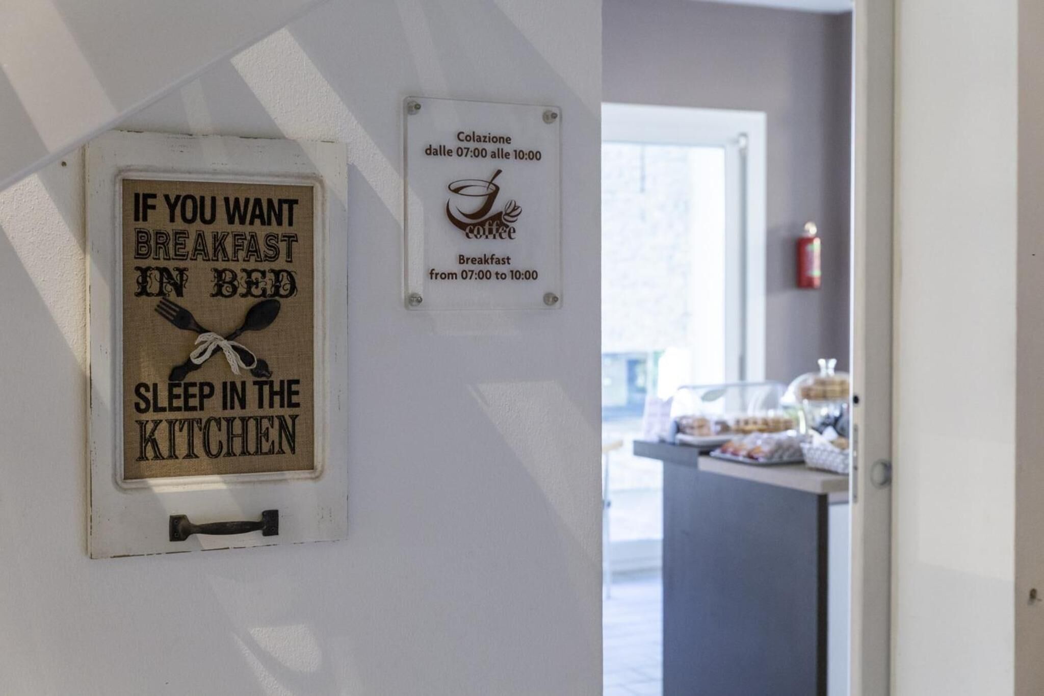 A sign offering breakfast in bed from 7:00 to 10:00 and another sign indicating breakfast from 7:00 to 10:00.