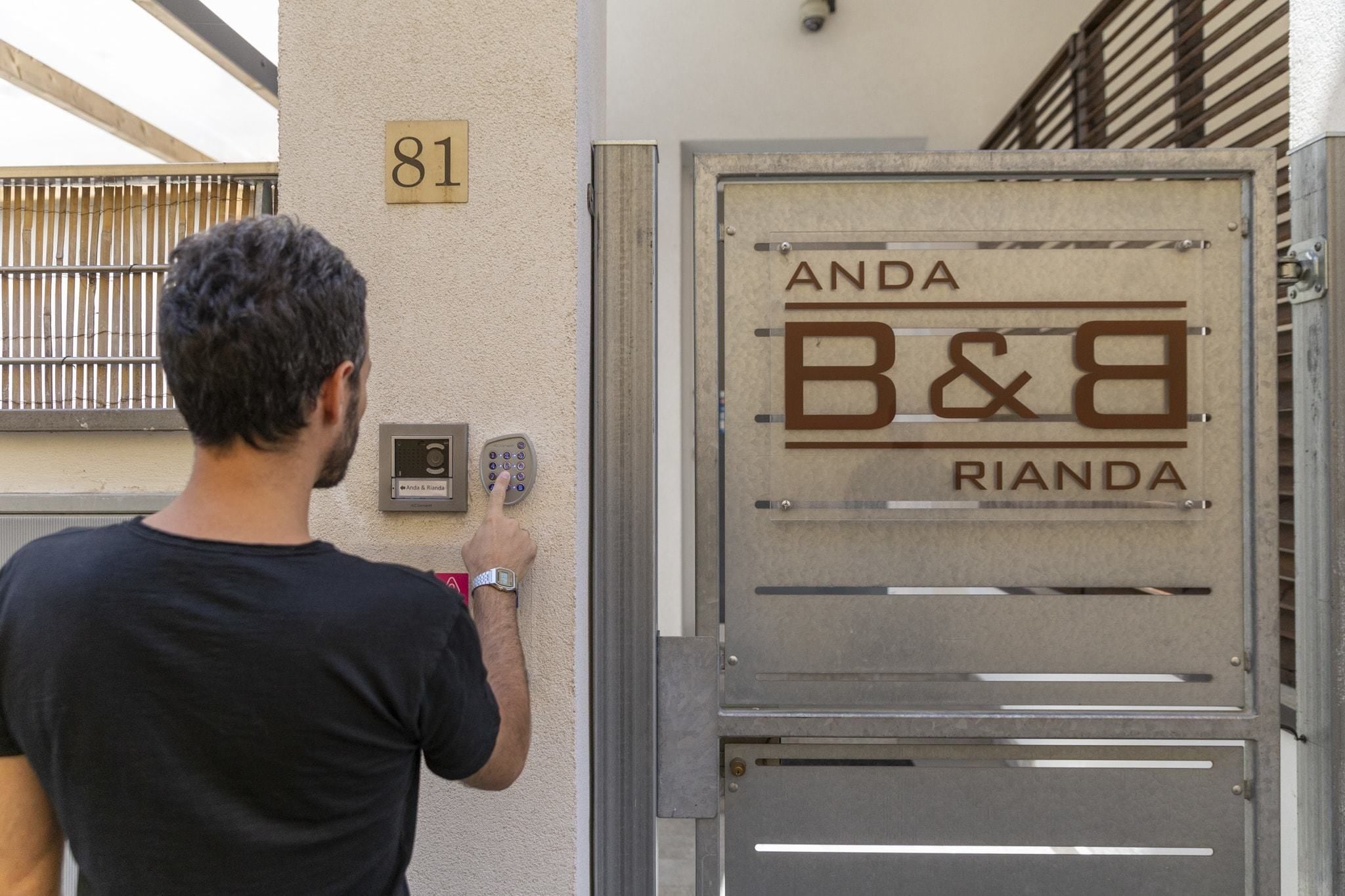 Ein Mann betritt ein Gebäude mit einem Zahlenschloss und einem Schild mit der Aufschrift 'ANDA B&8 RIANDA'.