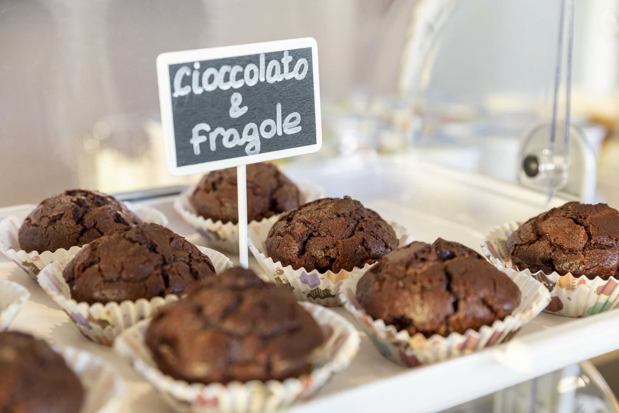 Una bandeja con muffins de chocolate y frangole en vasitos de papel.