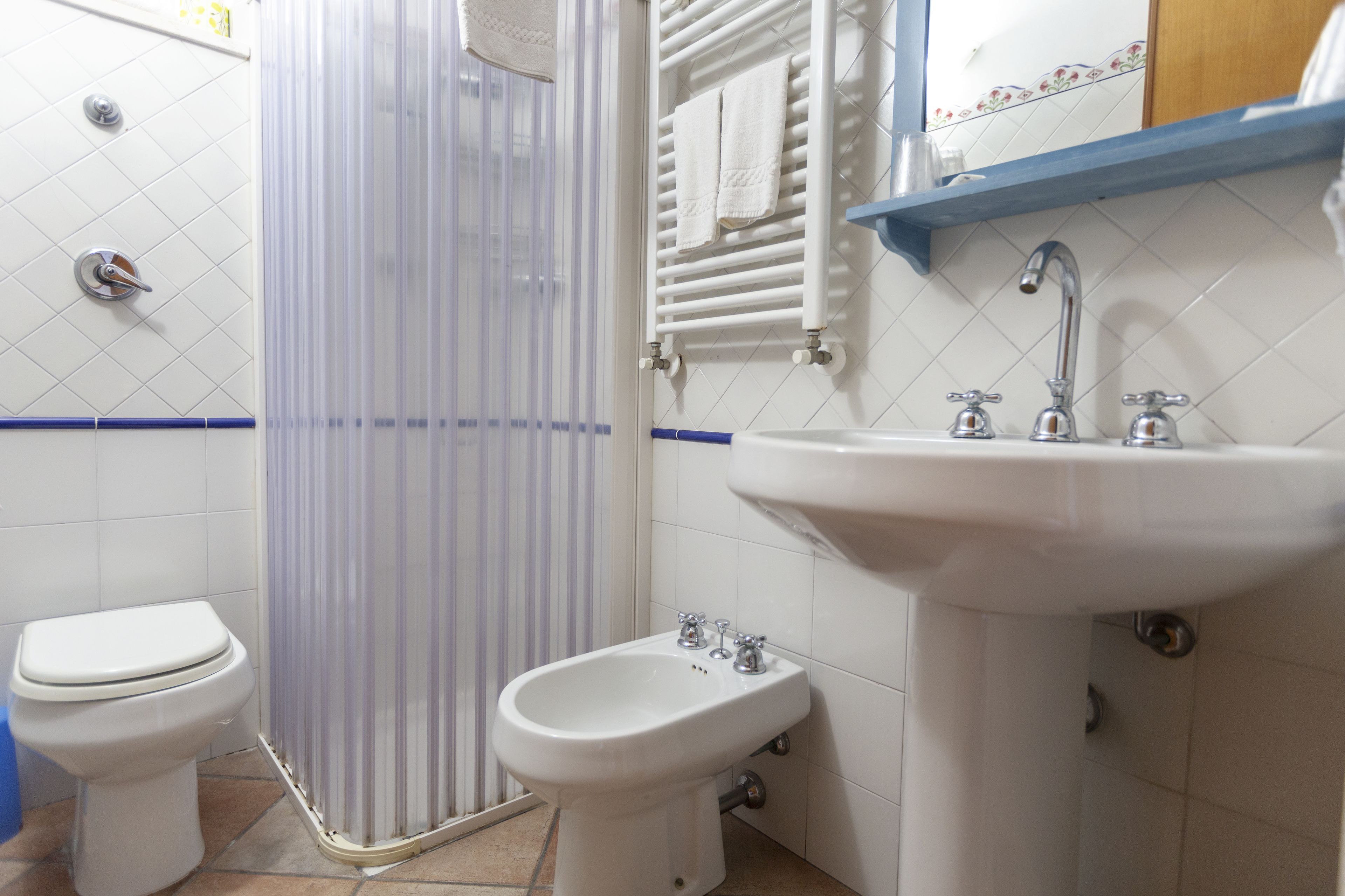 A bathroom with a toilet, bidet, and sink.