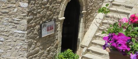 A stone building with a reception sign, a staircase, and potted plants.