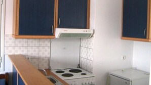 Una cucina con due pensili, un fornello e un frigorifero.