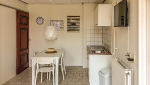 Uma cozinha compacta com área de refeições, um relógio e uma placa com a frase 'lar é o meu lugar favorito'.