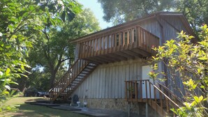 Un edificio rústico de madera con una escalera que lleva a una terraza.