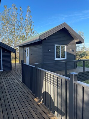 A modern cabin with a deck, a door, and a window. - Cosy cottage with hot tub on Golden Circle, sleeps up to 6 people (Selfoss)