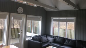 Une pièce avec un canapé en cuir noir, une table en bois et une horloge au mur.