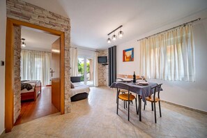 Una habitación amplia con zona de comedor, una cama y televisor.