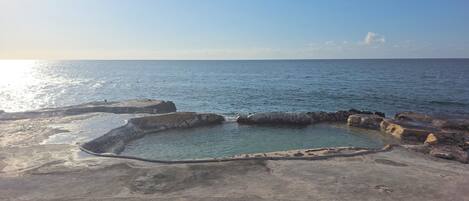 A coastal landscape with a clear sky and calm sea.