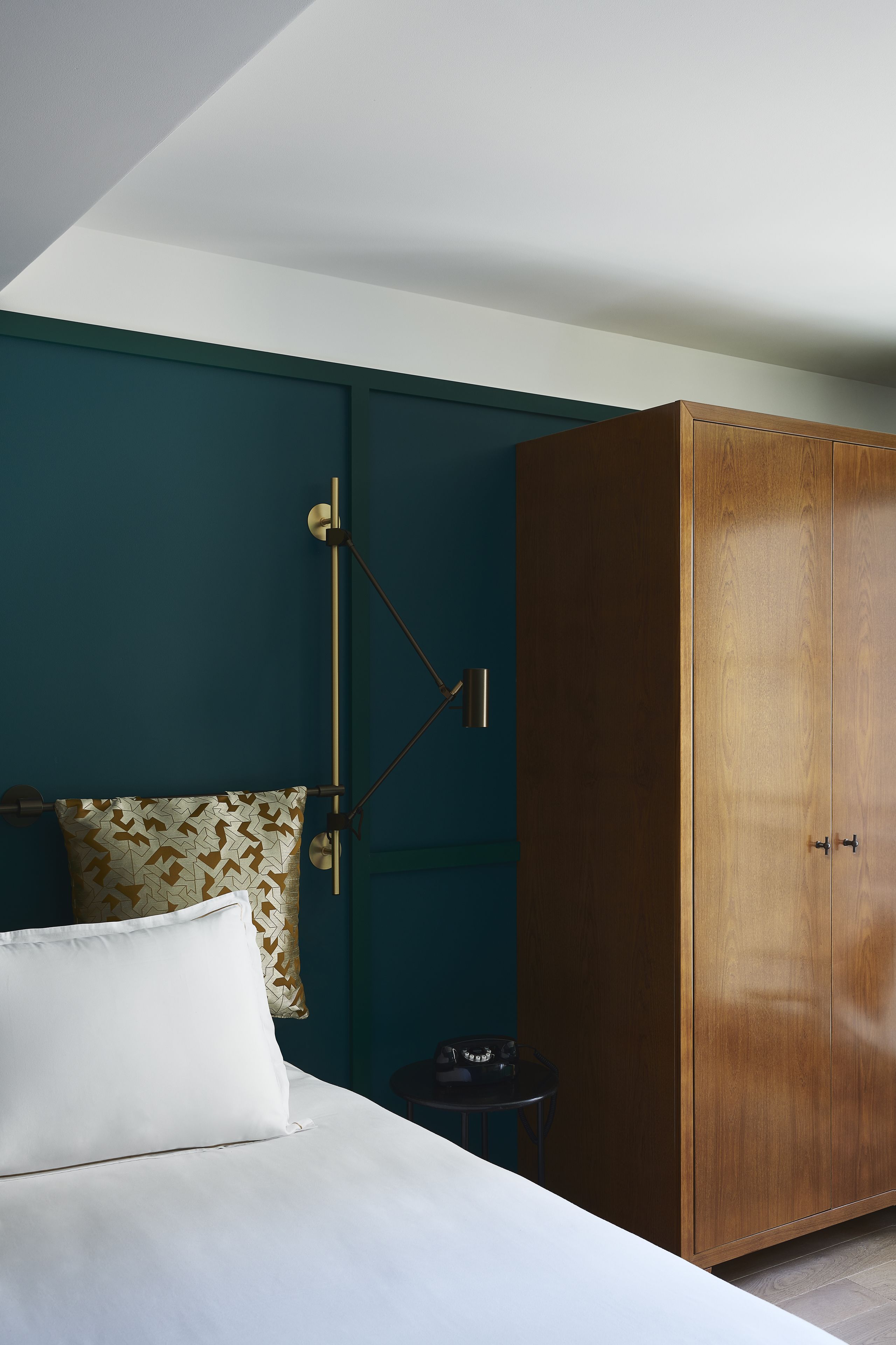 Une chambre à coucher comprenant un lit, une armoire, une table de chevet et une lampe.