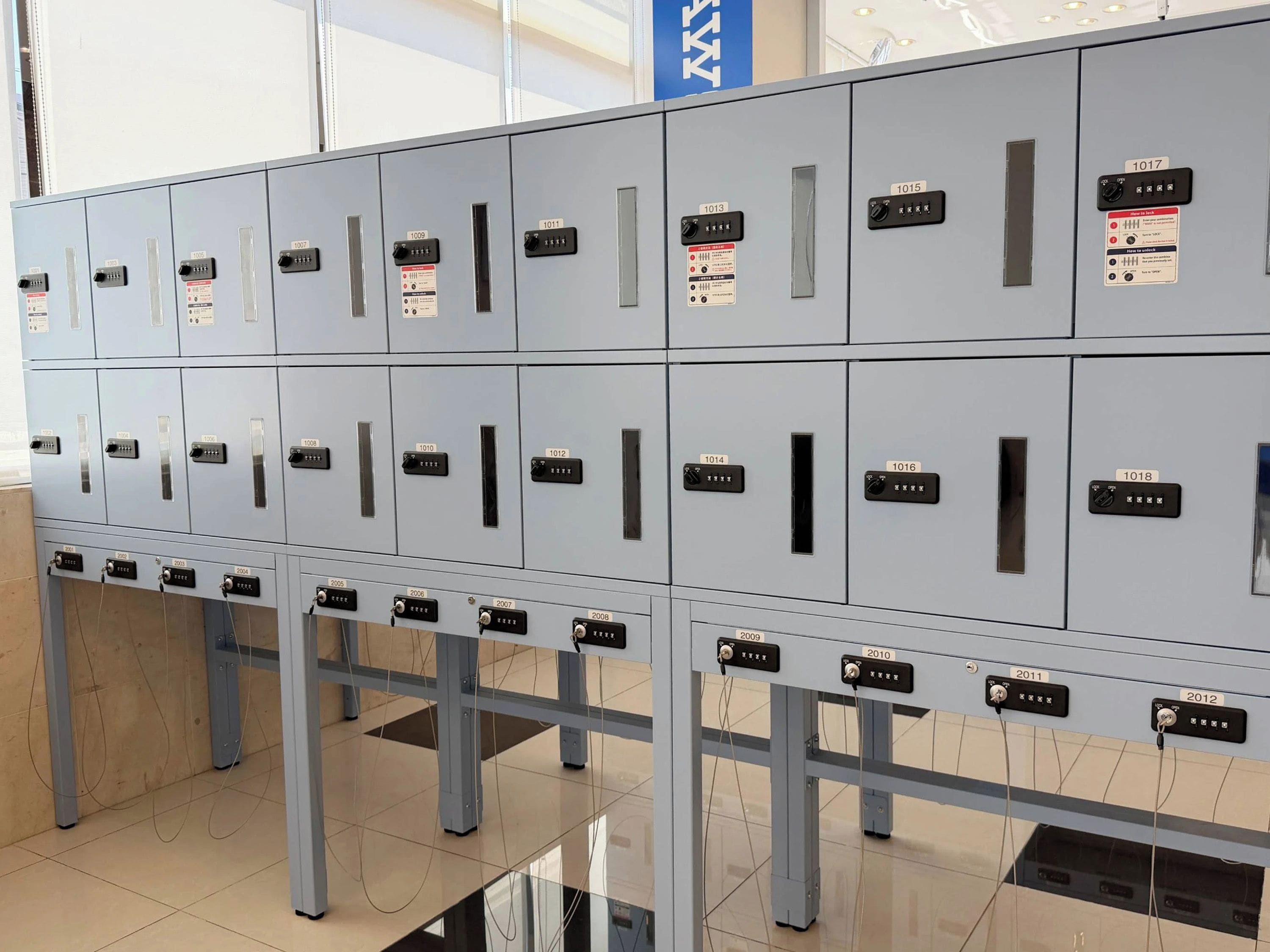 Una fila de taquillas metálicas grises con etiquetas numeradas del 1001 al 2012.