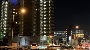 A multi-story hotel with illuminated signage, a busy street with cars, and directional signs. - Toyoko Inn Nishi Funabashi Baraki Inter (Ichikawa)