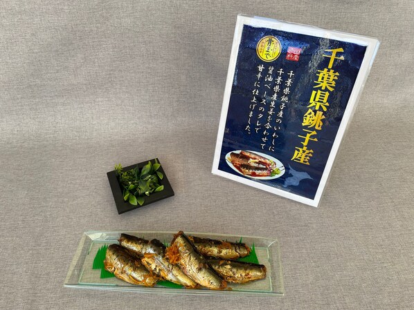 A menu with Japanese text and a picture of grilled fish.