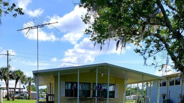 A single-story house with a covered porch, a small deck, and a satellite dish. - Waterfront property! (Welaka)